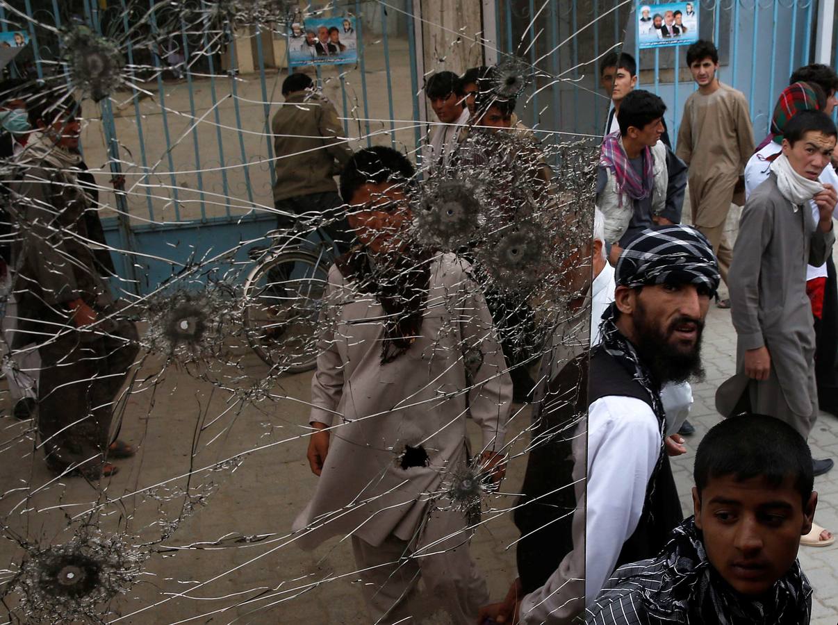 La vida cotidiana en Kabul. Ciudadanos pasan junto a un establecimiento tras un ataque.