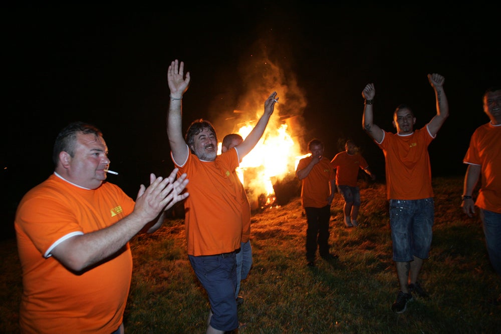 Ambiente festivo en Mareo, entre orbayu, paraguas y fuego.