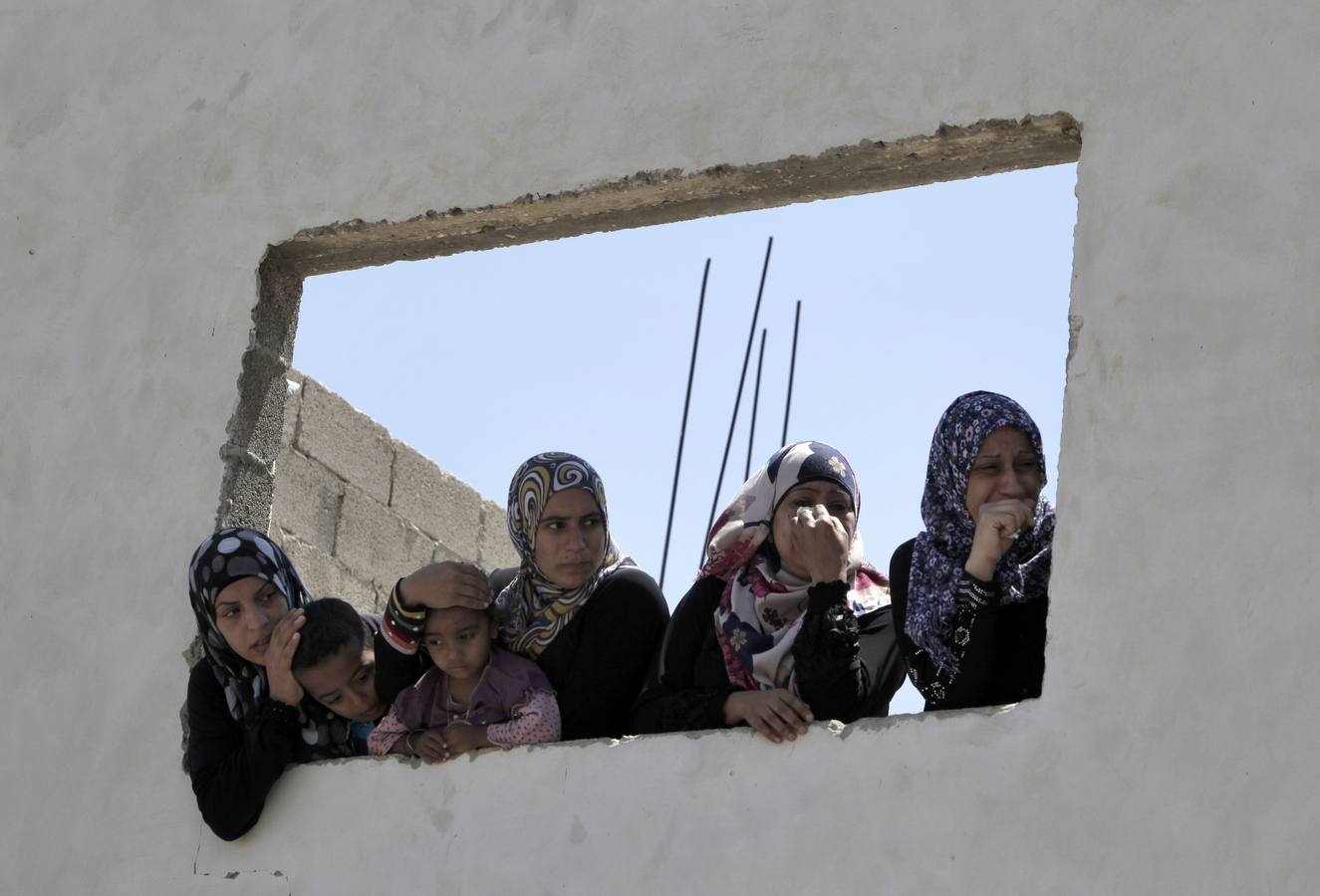 Mujeres y niños con gesto apenado en el funeral del joven palestino muerto. 