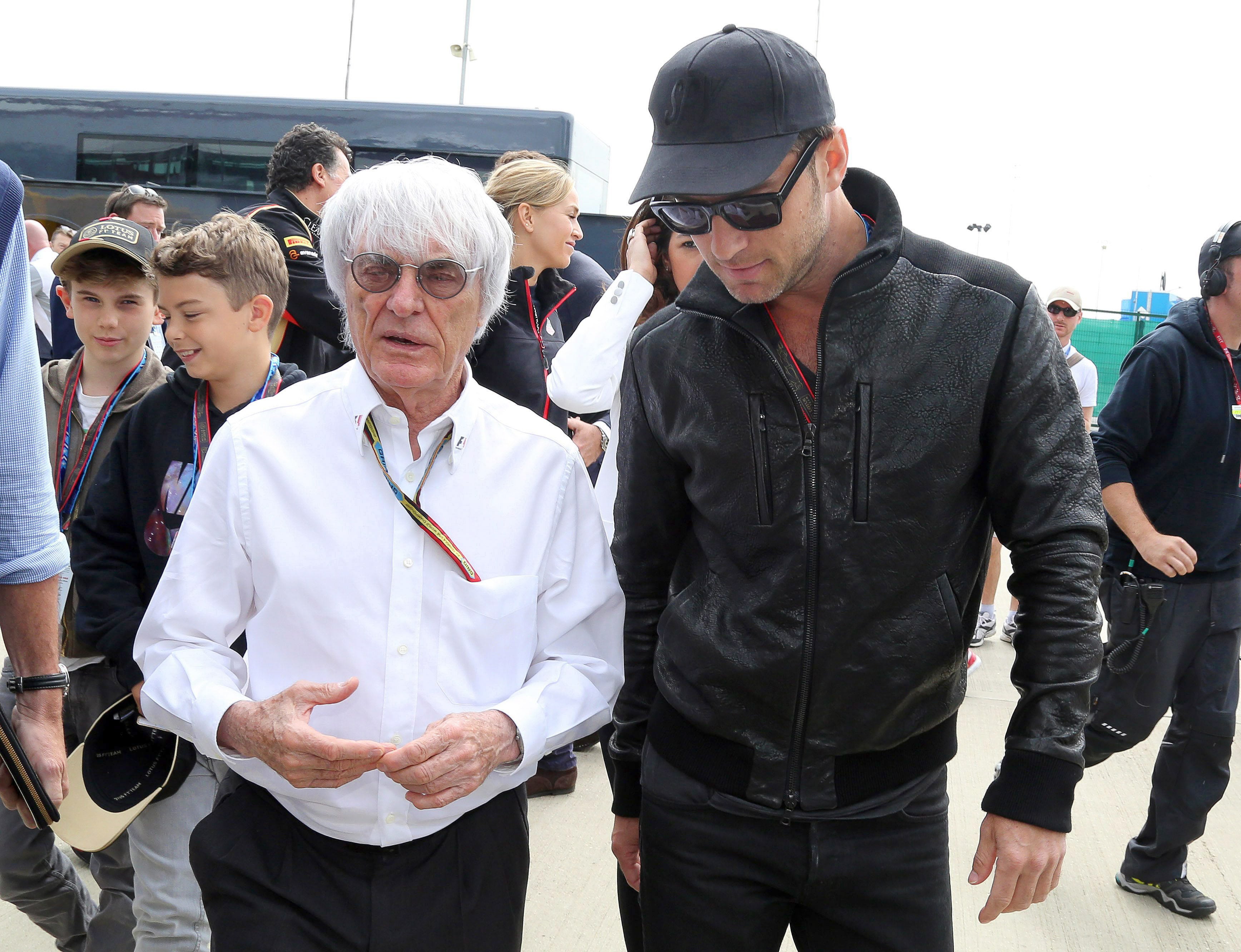 El 'jefe' de la Formula 1, Bernie Ecclestone (i) pasea por el paddock junto al actor británico Jude Law.