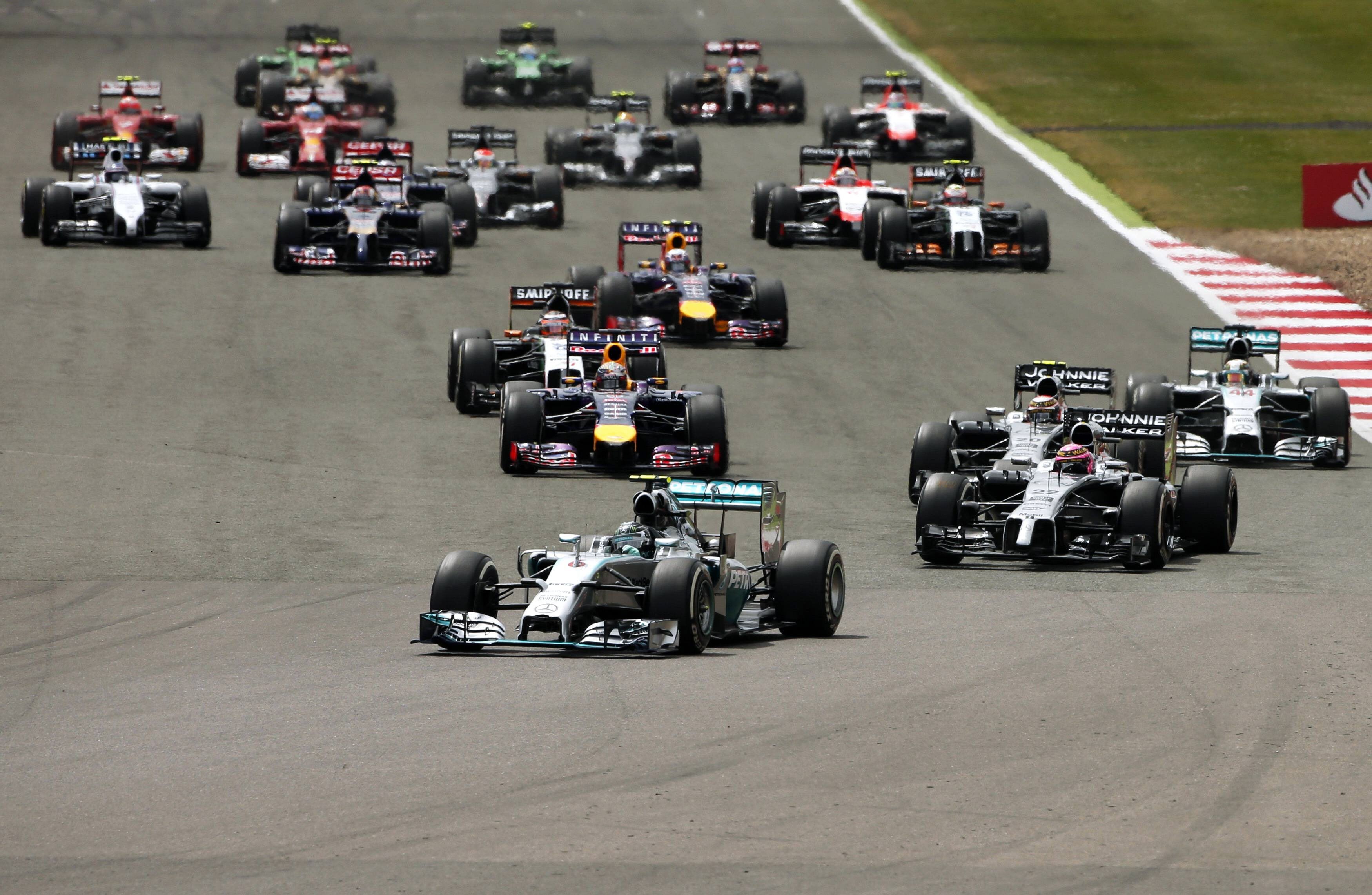 Nico Rosberg lidera el grupo en la primera curva del Gran Premio de Silverstone.