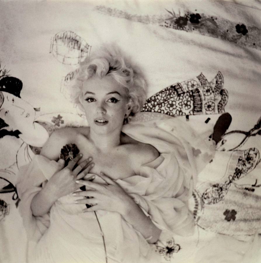 52 años del adiós de un mito. Una imagen sensual de Marilyn Monroe desnuda en una cama y con una rosa.