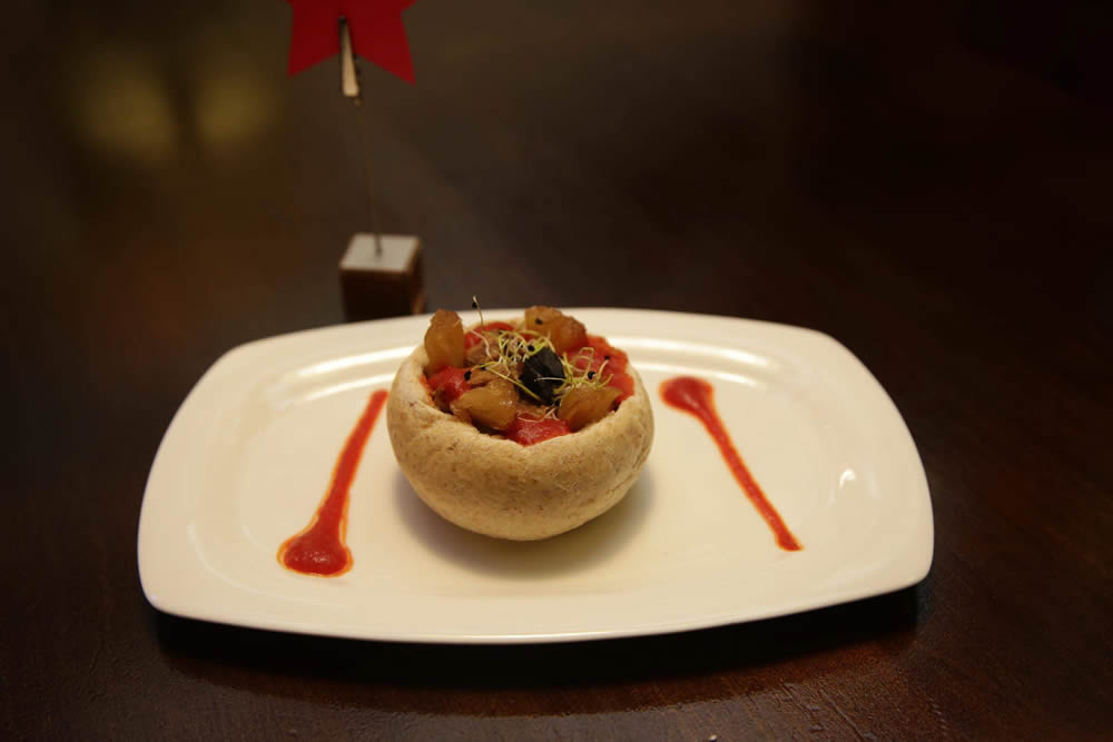 Escanda-lo (Barrica Blanca). Pan de escanda, carne de ternera gobernada, piña caramelizada, crma de pimiento, ajo negro y bortes de puerro.