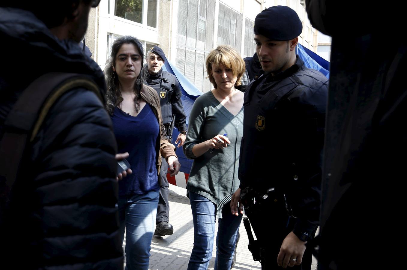 Dos profesoras son escoltadas por agentes de la Policía.