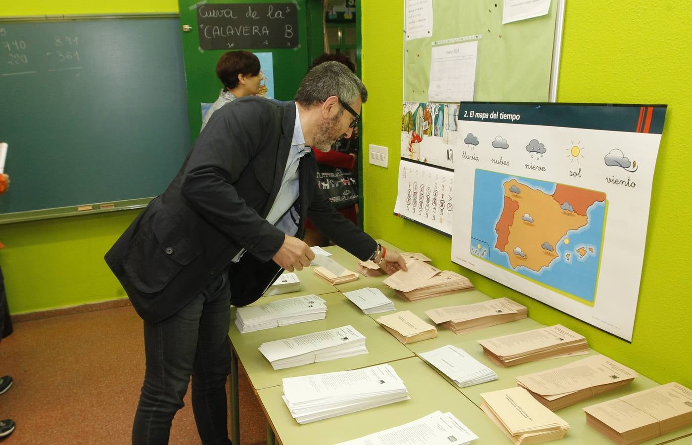 El candidato de Ciudadanos en Gijón, frente a las papeletas y el mapa del tiempo.