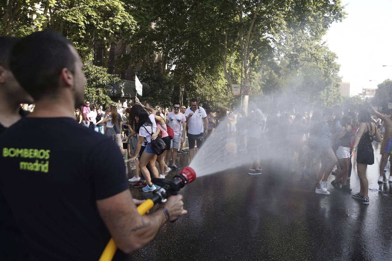 Un bombero de Madrid refresca a los participantes del desfile.