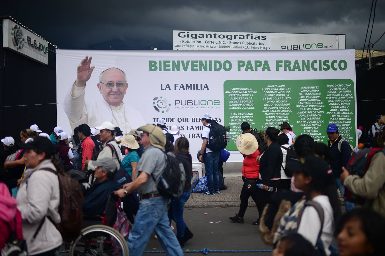 Algunas personas marchan frente a una imagen del papa Francisco.