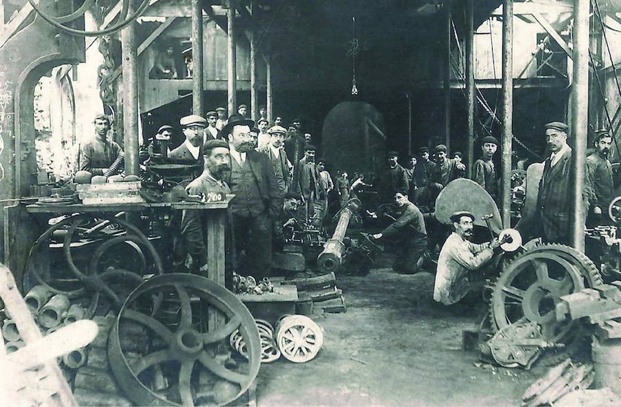 Taller del astillero Riera y Menéndez. A la izquierda, con traje y sombrero, Estanislao Menéndez, detrás, con gorra y barba, Luis Riera.