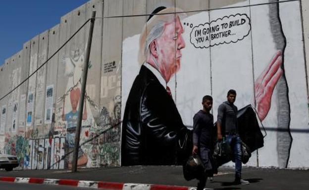 Una pintada en el muro de separación israelí caricaturiza a Trump y su muro
