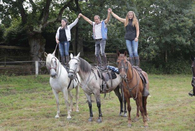 Tres participantes realizan una acrobacia antes de iniciar la Ruta a Caballo de Deva. 