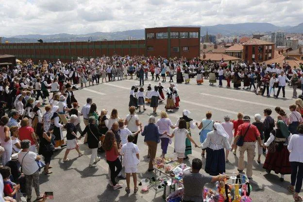 Cientos de personas se dieron la mano para bailar en la multitudinaria 'Danza prima' del Día de Asturias en Gijón. 