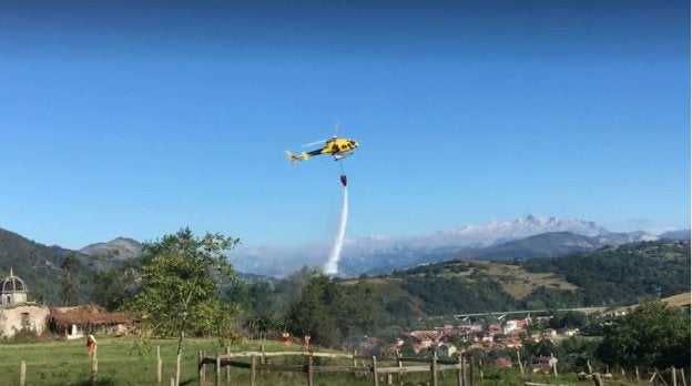 El helicóptero descarga agua sobre el incendio. 