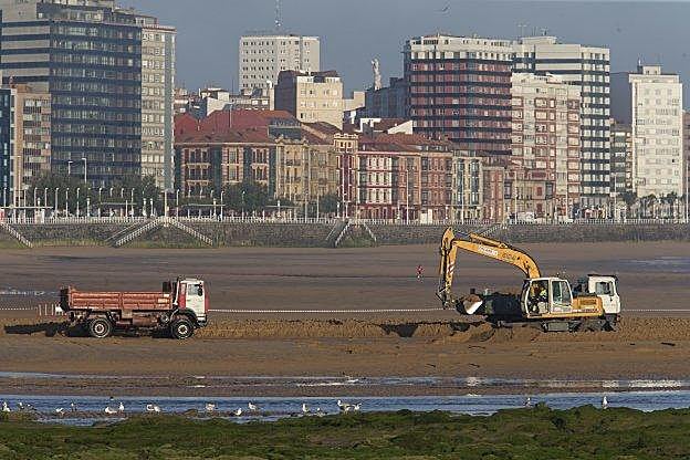 Trabajos de trasvase de arena en la playa de San Lorenzo en junio del año pasado. 