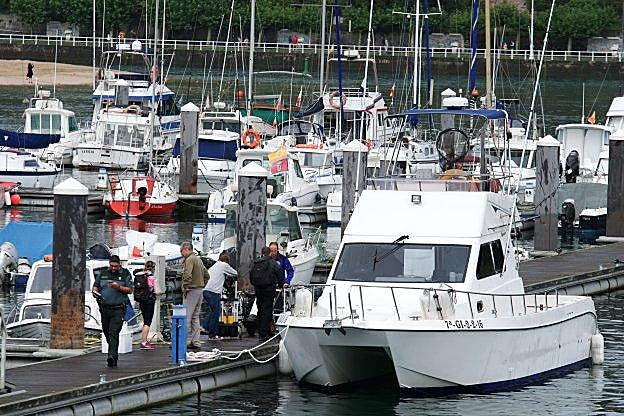 Los compañeros del submarinista desaparecido a su regreso al puerto deportivo de Ribadesella. 