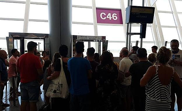 Un grupo de pasarjeros, ante la puerta de embarque.