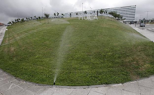 Aspersores del HUCA en pleno funcionamiento ayer por la tarde. Una imagen del hospital del Principado que contrasta con las restricciones de riego ordenadas esta semana por el Ayuntamiento de Oviedo. 