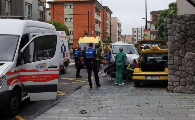 Bomberos, Policía Local y personal sanitario atienden a la conductora del turismo accidentado, ayer en Llanes. 