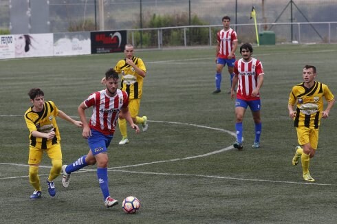 Un jugador del Candás conduce el balón en la medular. 