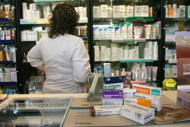 Una farmacéutica revisa los productos expuestos en una de las estanterías. 