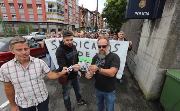 Tres agentes cortan sus carnets de afiliado durante la concentración mantenida esta mañana frente a la comisaría de Avilés 