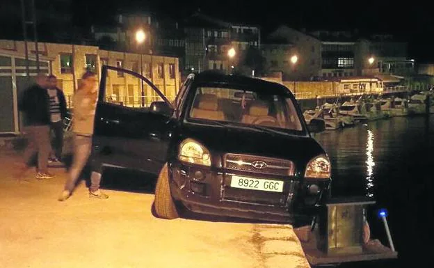 Dos jóvenes turistas, a punto de caer al agua en el puerto llanisco