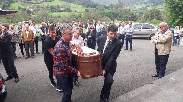 Familiares de Julio César Álvarez trasladan el féretro a la iglesia ante la mirada de los asistentes. 