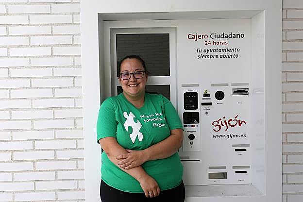 Lorena García, junto al cajero ciudadano de la sede vecinal de Nuevo Roces, que acumula meses sin uso.