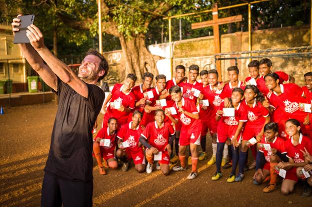 El futbolista asturiano, durante su viaje a India, se fotografía con los jóvenes jugadores.