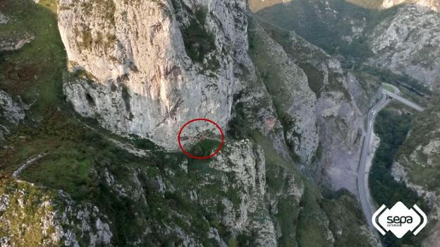 Ubicación del herido tras despeñarse desde una altura de cinco metros. Abajo, momento del rescate del escalador en Morcín. 