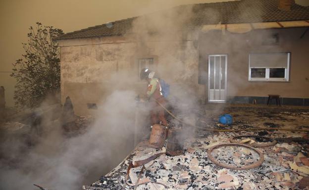 Un bombero sofoca el fuego en una vivienda de la localidad de Cornollo, en Allande.