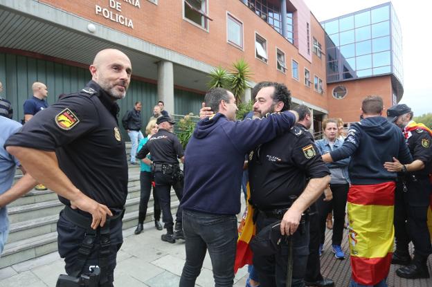 Los agentes de la Unión de Prevención y Reacción que fueron en comisión de servicio a Cataluña, uniformados, son recibidos a las puertas de la Comisaría por sus compañeros. 