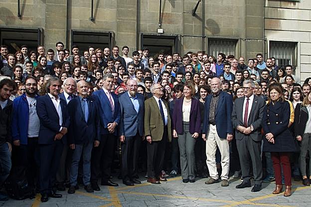 Los científicos, ante la facultad de Ciencias, rodeados de profesores y alumnos. 