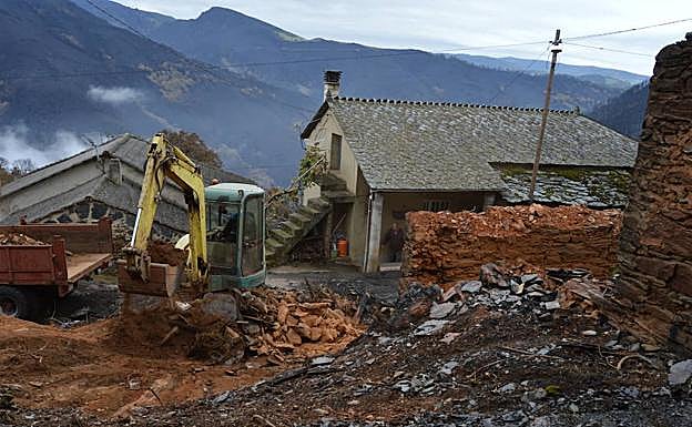 En Cornollo, Allande, una excavadora derriba los restos de las viviendas arrasadas por las llamas. 