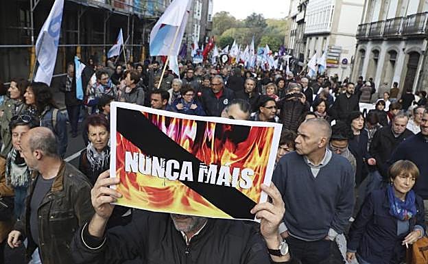 Un hombre porta un cartel con el lema 'Nunca mais', durante la concentración.