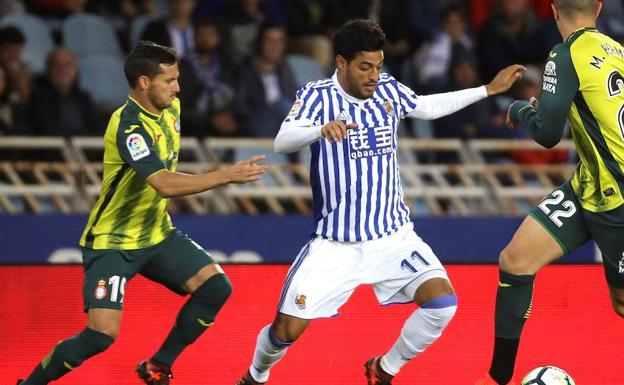 Carlos Vela, luchando un balón con Pablo Piatti.