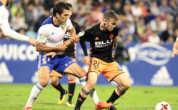 El centrocampista del Real Zaragoza Zapater (i) lucha el balón con Antonio Latorre, defensa del Valencia.