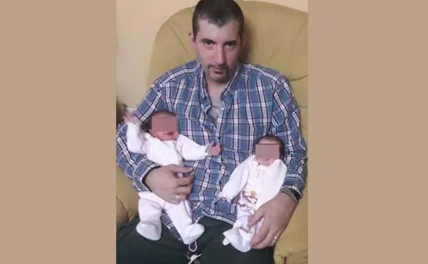 Gonzalo sostiene en brazos a sus dos hijas. 