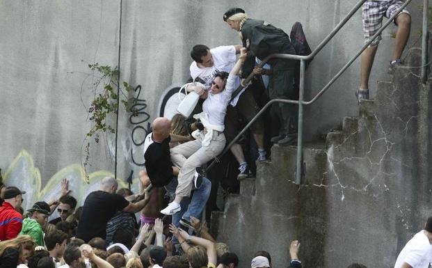 Una mujer es rescatada de la multitud por policías y civiles en la Love Parade de 2010. 