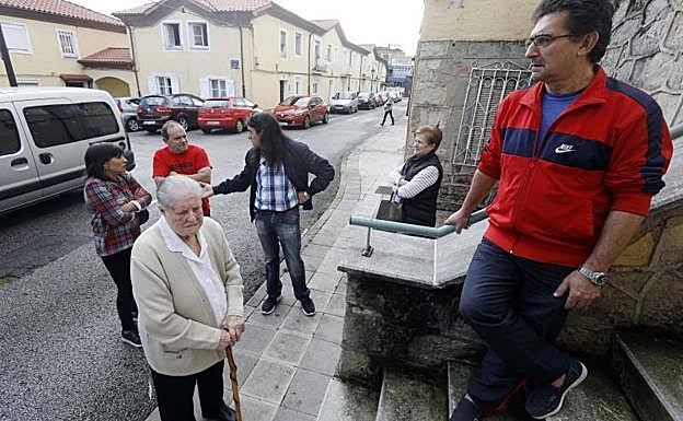 Imagen. Algunos de los inquilinos afectados por los desahucios, en el acceso de uno de los edificios de El Nodo.