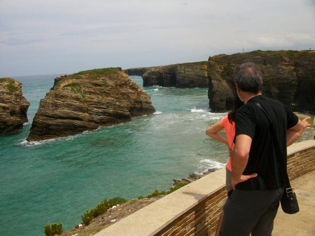 Un turista observa la playa de Las Catedrales desde el acantilado. 