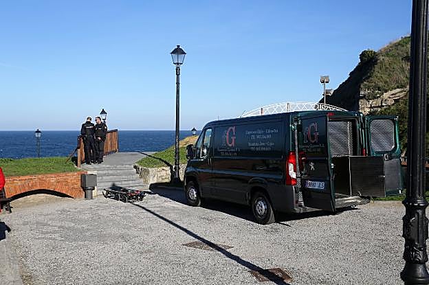 Dos policías nacionales junto a la furgoneta de la funeraria, en la pista de skate de Cimavilla. 