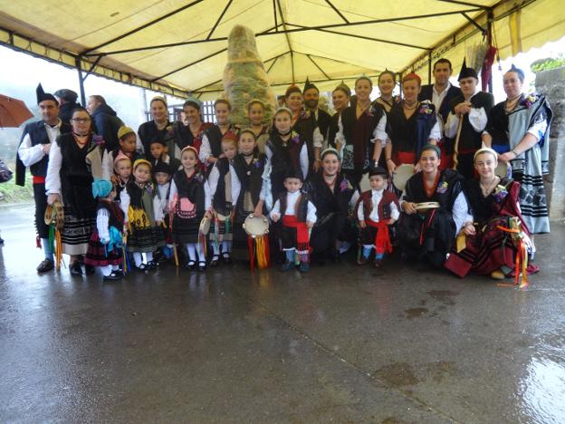 Los participantes en la jornada festiva posan junto a uno de los ramos en la carpa. 