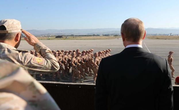 El presidente ruso, Vladimir Putin (d), y el ministro de defensa ruso, Sergei Shoigu (i), visitan la base aérea de Hmeymin, en Siria.
