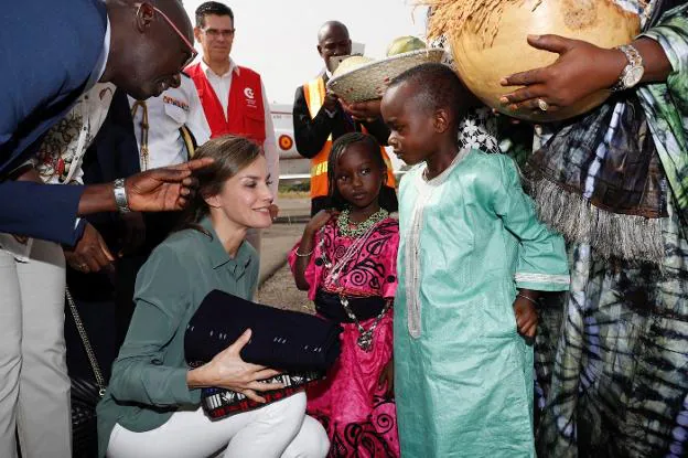 La Reina Letizia, con unas niñas, durante su viaje de cooperación al país africano. 