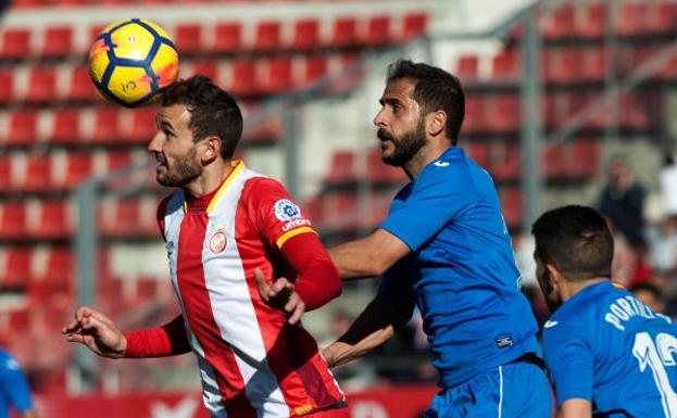 El delantero del Girona Cristhian Stuani (i) disputa un balón con el centrocampista del Getafe Sergio Mora (d).