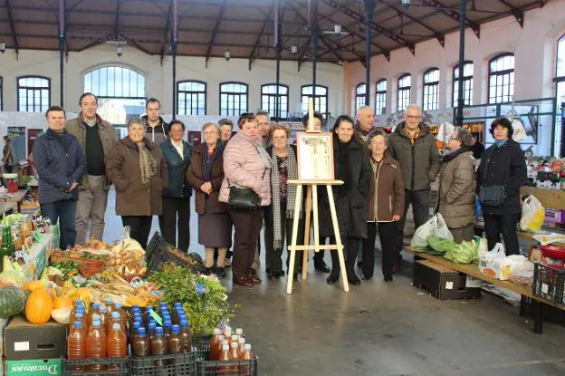 Las vendedoras de la plaza, acompañadas por el alcalde Alejandro Vega y miembros de Cubera, junto al diploma que exhibirán en las instalaciones del mercado semanal. 