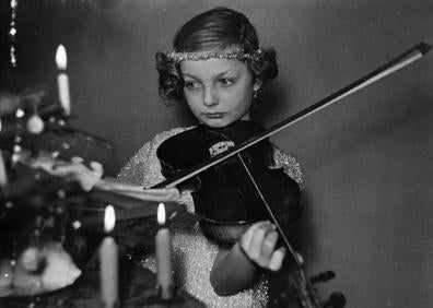 Imagen secundaria 1 - En la primera imagen, Día de Reyes en 1955; debajo, una niña tocando el violín junto al árbol en 1960 y, en la tercera fotografía, Reyes Magos de los cincuenta.