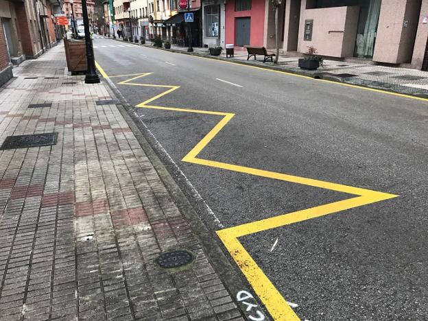 Las líneas amarillas que prohíben estacionar en la vía principal. 