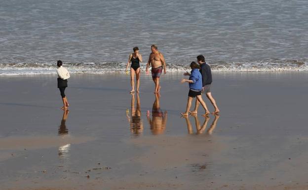 La playa de San Lorenzo de Gijón recibió a algunos bañistas este dos de enero. 