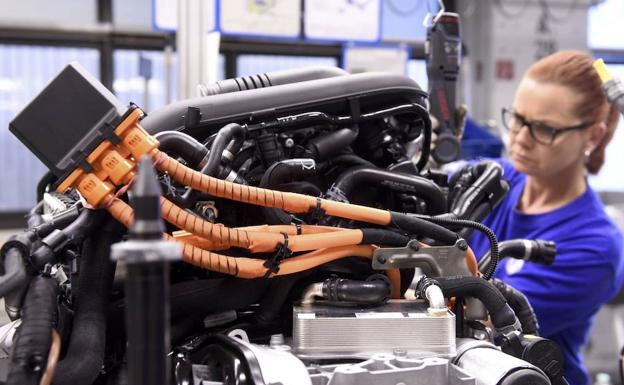 Una trabajadora montando un motor en una fabrica de Volkswagen en Alemania.